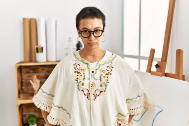 Young hispanic woman with short hair at art studio depressed and worry for distress, crying angry and afraid. sad expression. 