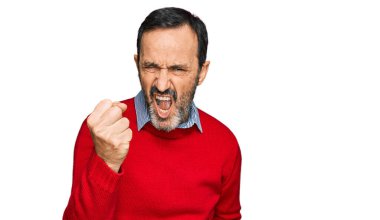 Orta yaşlı İspanyol bir adam, günlük kıyafetler giyiyor kızgın ve kızgın. Öfkeyle bağırırken yumruğunu kaldırıyor. öfke ve agresif konsept. 