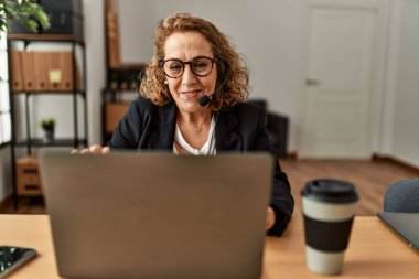 Middle age caucasian call center agent woman working at the office.