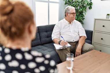 Senior psychologist man at consultation office looking to side, relax profile pose with natural face and confident smile. 