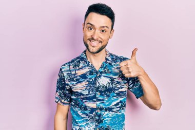 Neşeli ve pozitif gülümseyen İspanyol asıllı genç adam, mükemmel ve onay işareti yapıyor. 
