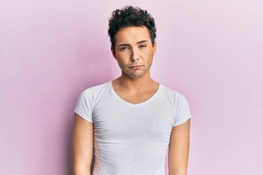 Young handsome man wearing casual white t shirt depressed and worry for distress, crying angry and afraid. sad expression. 