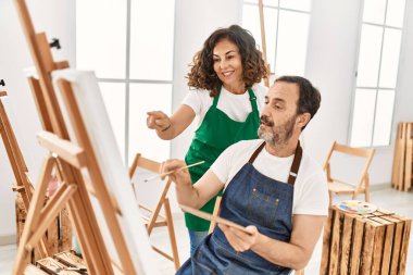 Sanat okulunda resim yaparken gülümseyen orta yaşlı öğrenci ve öğretmen..