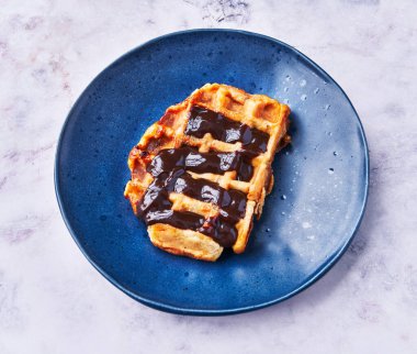  Mermer yüzeyinde çikolata olan lezzetli bir waffle tabağı.