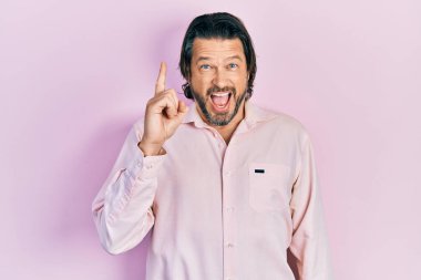 Sıradan kıyafetler giyen orta yaşlı beyaz bir adam başarılı bir fikri işaret ediyor. Heyecanlı ve mutlu. Bir numara.. 