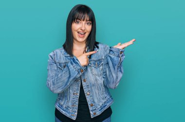 Gündelik kıyafetler giyen genç İspanyol kadın kameraya hayret ediyor ve gülümsüyor.. 