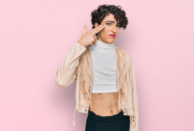 Handsome man wearing make up and woman clothes shooting and killing oneself pointing hand and fingers to head like gun, suicide gesture. 