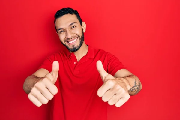 Hispánský Muž Vousy Neformální Červené Tričko Schvalující Dělá Pozitivní Gesto — Stock fotografie