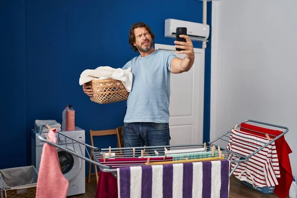 Handsome Middle Age Man Holding Laundry Basket Doing Selfie Picture — стоковое фото