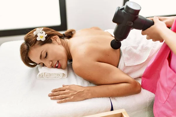 Young Latin Woman Having Back Massage Session Using Percussion Gun — Stock fotografie