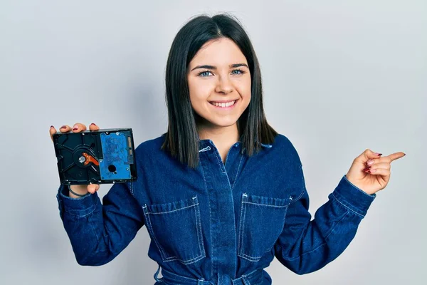 Young Brunette Woman Holding Hdd Disk Smiling Happy Pointing Hand — Stok fotoğraf