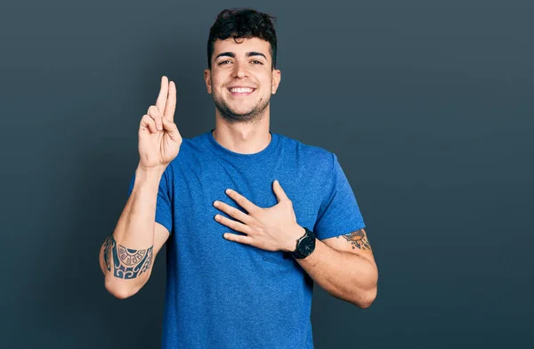 Junger Hispanischer Mann Lässigem Shirt Lächelt Und Schwört Mit Der — Stockfoto