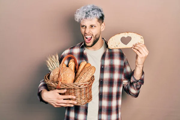 Young Hispanic Man Modern Dyed Hair Holding Wicker Basket Bread — 스톡 사진