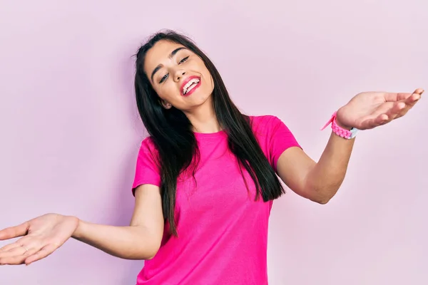 Young Hispanic Girl Wearing Casual Pink Shirt Smiling Cheerful Offering — Stok fotoğraf