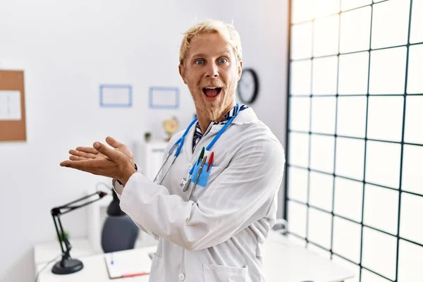 Young Blond Man Wearing Doctor Uniform Stethoscope Clinic Pointing Aside — Stok fotoğraf