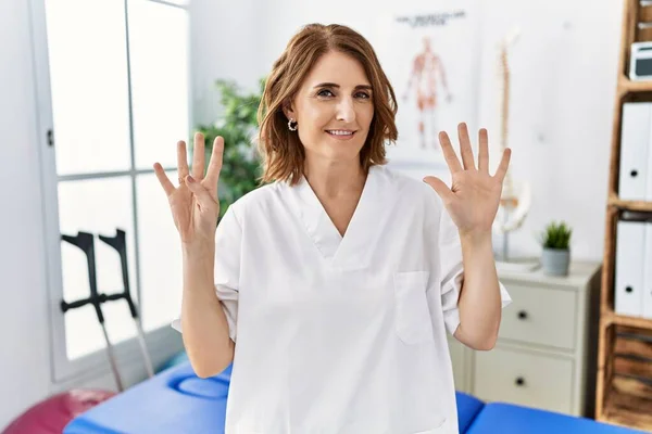Mulher Fisioterapeuta Meia Idade Trabalhando Clínica Recuperação Dor Mostrando Apontando — Fotografia de Stock
