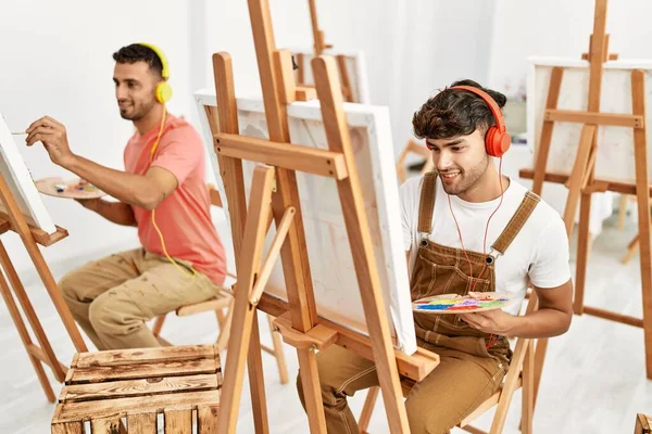 2人のヒスパニック系の男性カップルが音楽を聴き アートスタジオで絵を描く — ストック写真