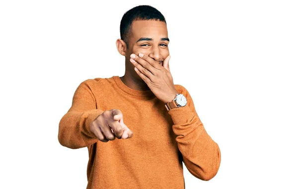 若いアフリカ系アメリカ人の男性がカジュアルな服を着て笑いながら 手を口にしてカメラに指を向け恥の表情 — ストック写真