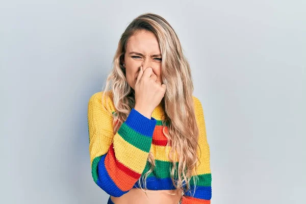 Beautiful Young Blonde Woman Wearing Colored Sweater Smelling Something Stinky — Foto de Stock