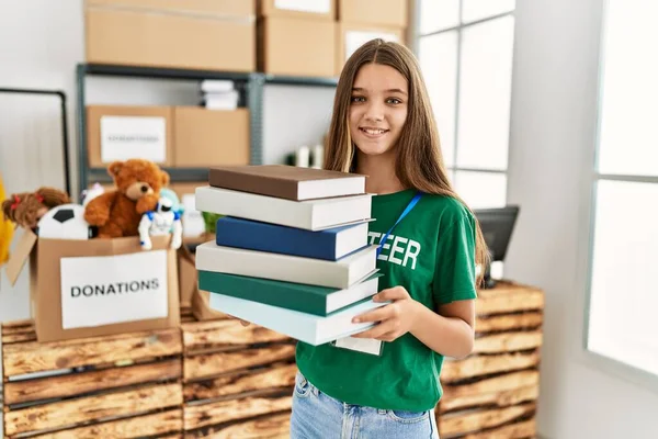Schattig Meisje Draagt Vrijwilligersuniform Met Boeken Een Liefdadigheidscentrum — Stockfoto