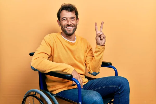 Tekerlekli Sandalyede Oturan Sakallı Yakışıklı Adam Kameraya Bakıp Zafer Işareti — Stok fotoğraf