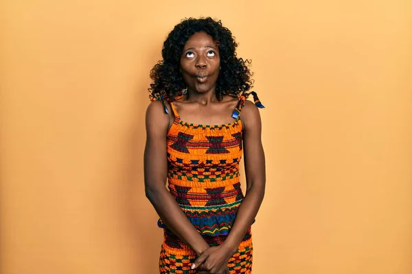 狂気とコミカルなジェスチャーで魚の顔を作る伝統的なアフリカの服を着て若いアフリカ系アメリカ人女性 面白い表現 — ストック写真