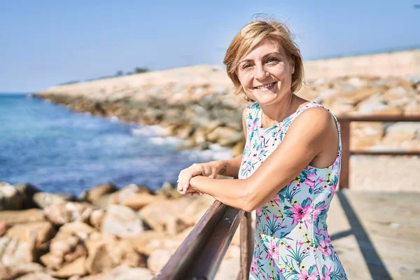 Orta yaşlı, güzel bir kadın. Deniz kenarında kendine güvenen.