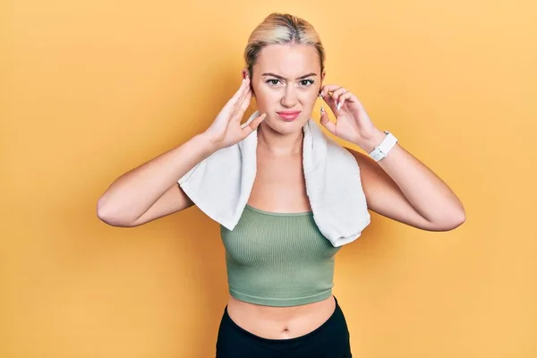 Young Blonde Girl Wearing Sportswear Towel Covering Ears Fingers Annoyed — Stockfoto
