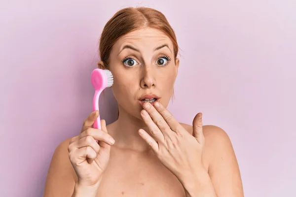 Young Irish Woman Using Facial Exfoliating Brush Covering Mouth Hand — Stock Photo, Image