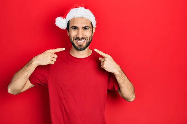 Молодий Іспаномовний Чоловік Різдвяному Капелюсі Усміхається Весело Показуючи Вказуючи Пальцями — стокове фото