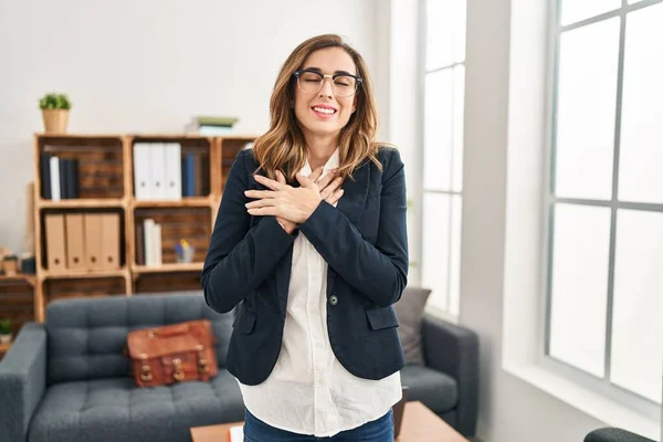 Young Woman Working Consultation Office Smiling Hands Chest Eyes Closed — Zdjęcie stockowe