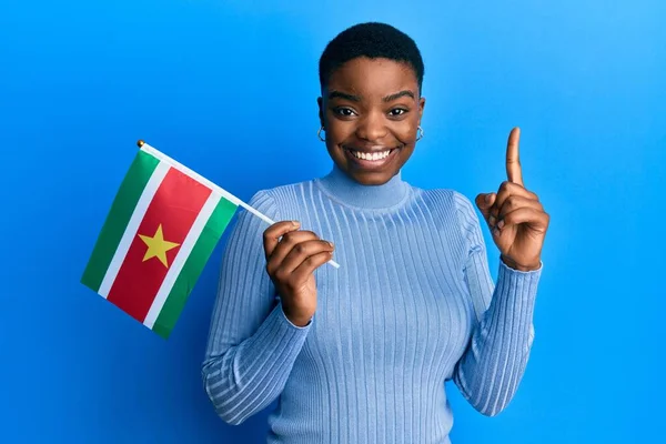 Young African American Woman Holding Suriname Flag Smiling Idea Question — Fotografia de Stock