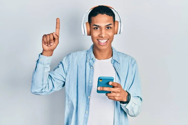 Young African American Guy Using Smartphone Wearing Headphones Surprised Idea — Stockfoto