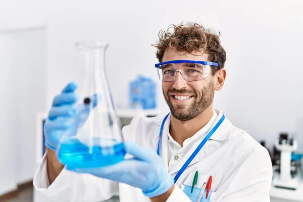 Joven Hispano Vistiendo Uniforme Científico Sosteniendo Tubo Ensayo Laboratorio —  Fotos de Stock