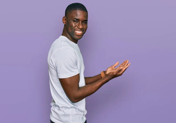 Νεαρός Αφροαμερικάνος Που Φοράει Λευκό Πουκάμισο Δείχνοντας Στην Άκρη Χέρια — Φωτογραφία Αρχείου