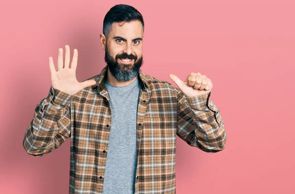 自信と幸せ笑みを浮かべている間 髭を生やしたヒスパニック系の男はカジュアルなシャツを着て表示され 指の数6で指摘 — ストック写真