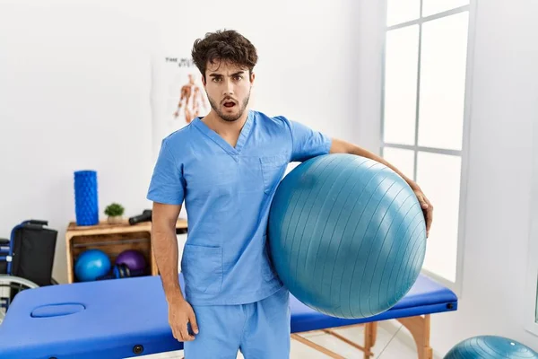 Hispanic Physiotherapy Man Working Pain Recovery Clinic Scared Amazed Open — Foto de Stock