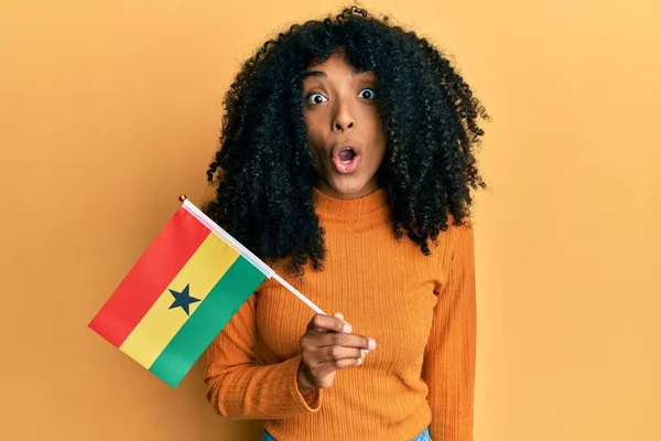 African American Woman Afro Hair Holding Ghana Flag Scared Amazed — стоковое фото