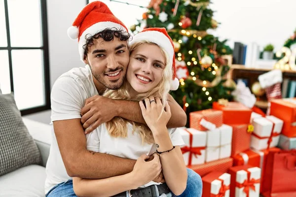 年轻夫妇笑得很开心 他们抱着圣诞节的礼物 坐在家里的沙发上 — 图库照片