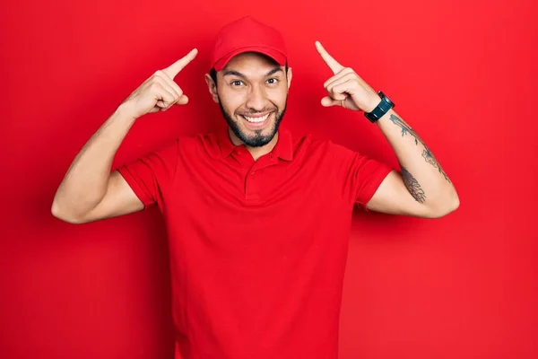 Hispanic Man Beard Wearing Delivery Uniform Cap Smiling Pointing Head — Stok fotoğraf