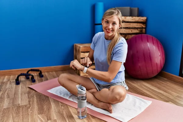 Young Blonde Woman Using Stopwatch Sitting Floor Sport Center — Stock Photo, Image