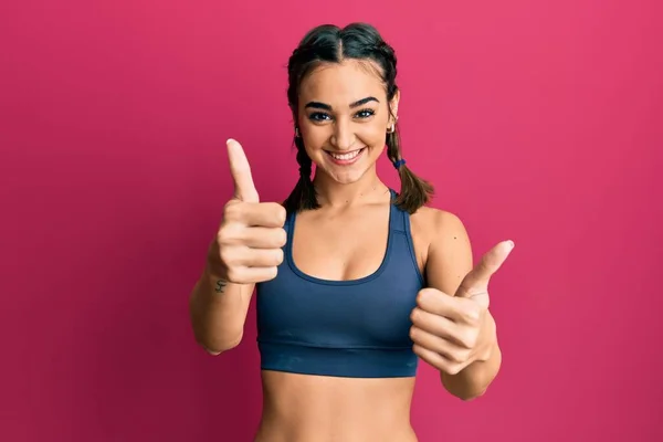 Young Brunette Girl Wearing Sportswear Braids Approving Doing Positive Gesture – stockfoto