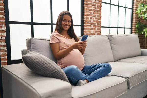 Młoda Latynoska Ciąży Pomocą Smartfona Domu — Zdjęcie stockowe