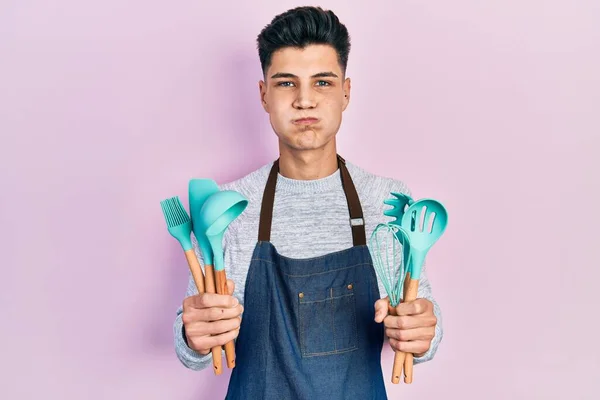 Young Hispanic Man Wearing Professional Baker Apron Holding Cooking Tools — Fotografia de Stock