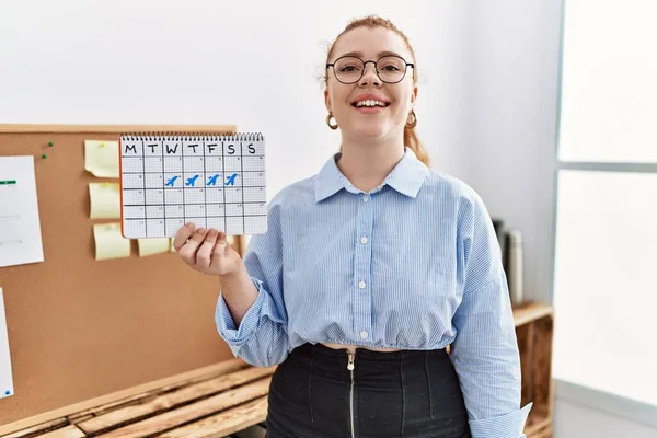 Young Redhead Woman Holding Travel Calendar Office Looking Positive Happy — Stock Photo, Image