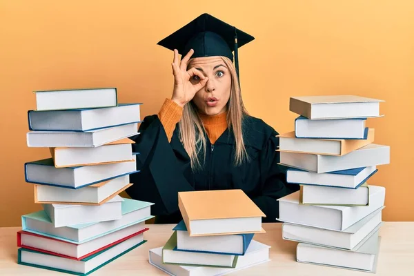 Young Caucasian Woman Wearing Graduation Ceremony Robe Sitting Table Doing — Stockfoto