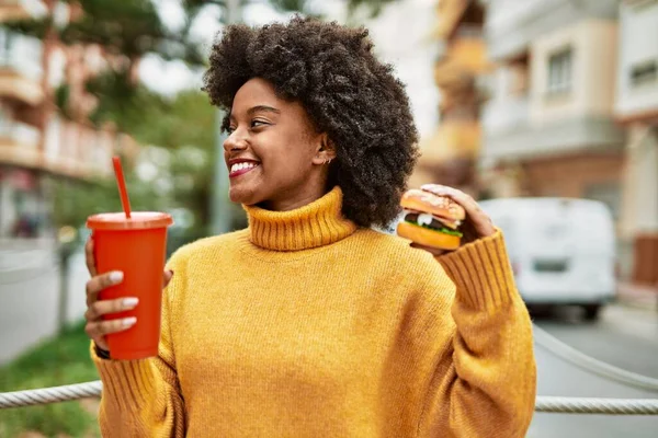 年轻的非洲裔美国女孩在城里吃着经典的汉堡包和苏打水 — 图库照片