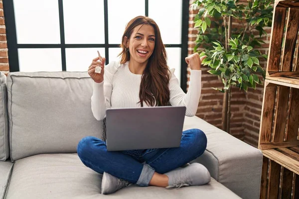 Young Brunette Woman Using Laptop Holding Keys New Home Smiling — Stock fotografie