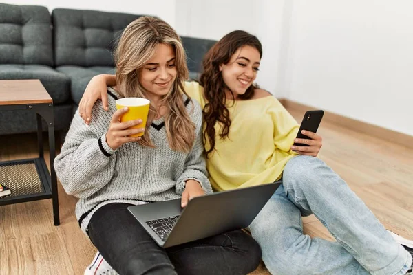 在家里用笔记本电脑和智能手机喝咖啡的年轻夫妇 — 图库照片