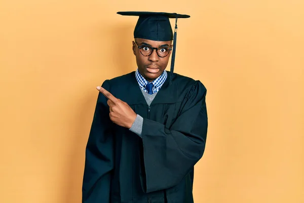 Νεαρός Αφροαμερικάνος Φοράει Καπέλο Αποφοίτησης Και Επίσημη Ρόμπα Δείχνοντας Στην — Φωτογραφία Αρχείου